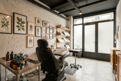 Intérieur d'un studio de tatouage professionnel en Auvergne-Rhône-Alpes avec chaise ergonomique, murs couverts de flash art et ambiance artistique urbaine